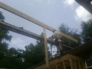 Carpenter setting a ridge beam over a new addition frame — Ice Dam Removal by Roofing Brothers in Tar Heel