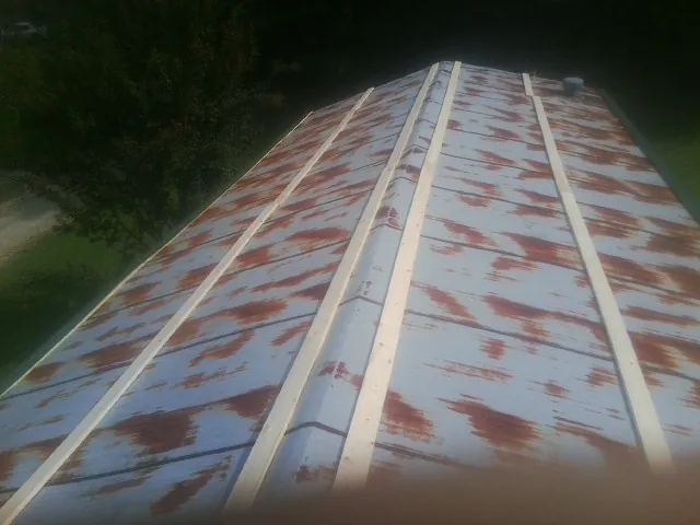 Rusted metal roof panels with new wood purlins before replacement — Storm Damage Roof Repair in Tar Heel by Roofing Brothers