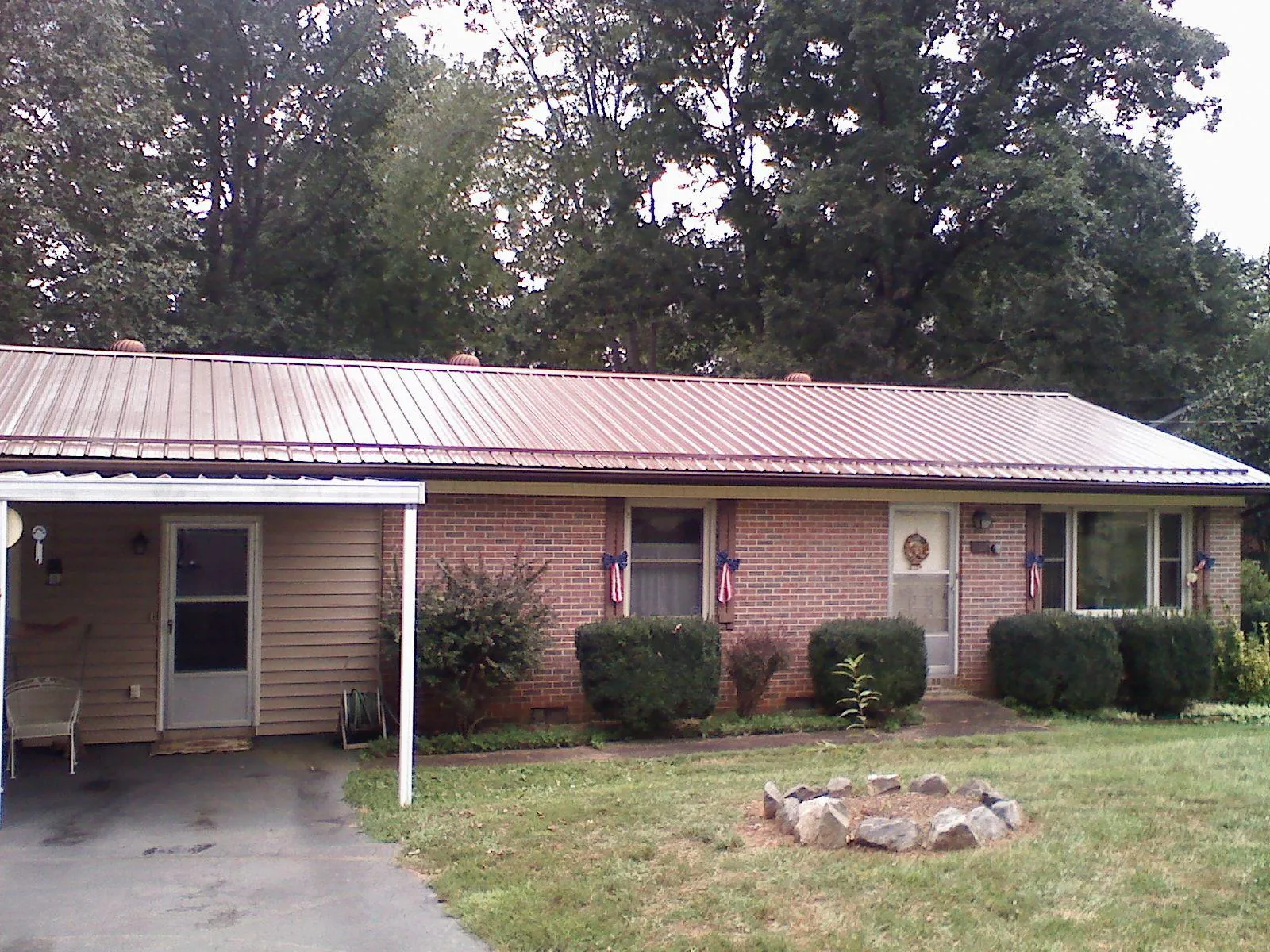 Bronze metal roof and carport on a brick ranch home — Roof Repair work by our crew in Tar Heel